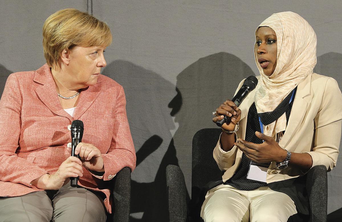 Angela Merkel en compagnie d'une jeune réfugiée de Gambie: entre ouverture et fermeté.
