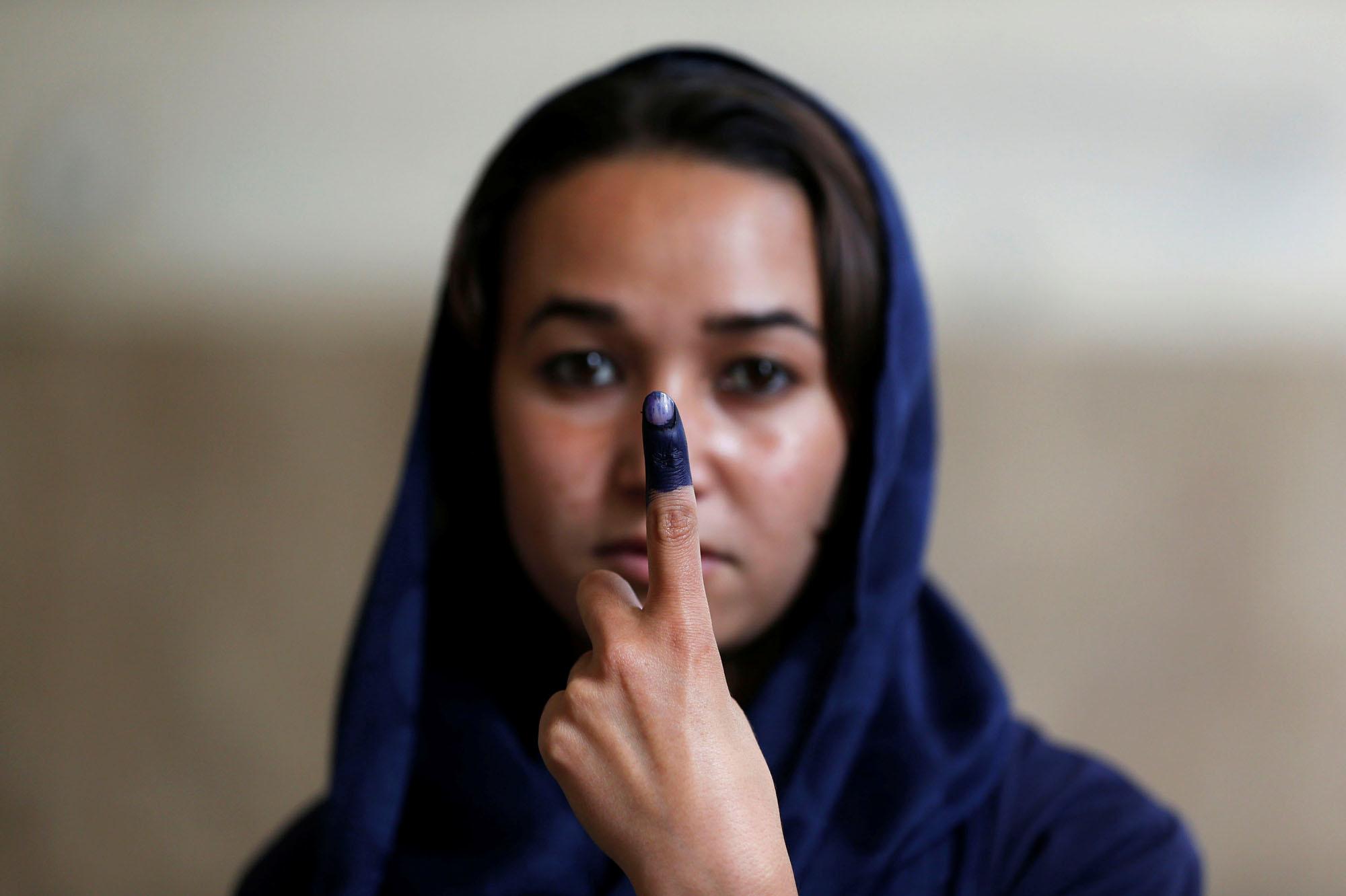 14 juin 2014 : une Afghane brandit son doigt taché d'encre après avoir voté lors de l'élection présidentielle à Kaboul.