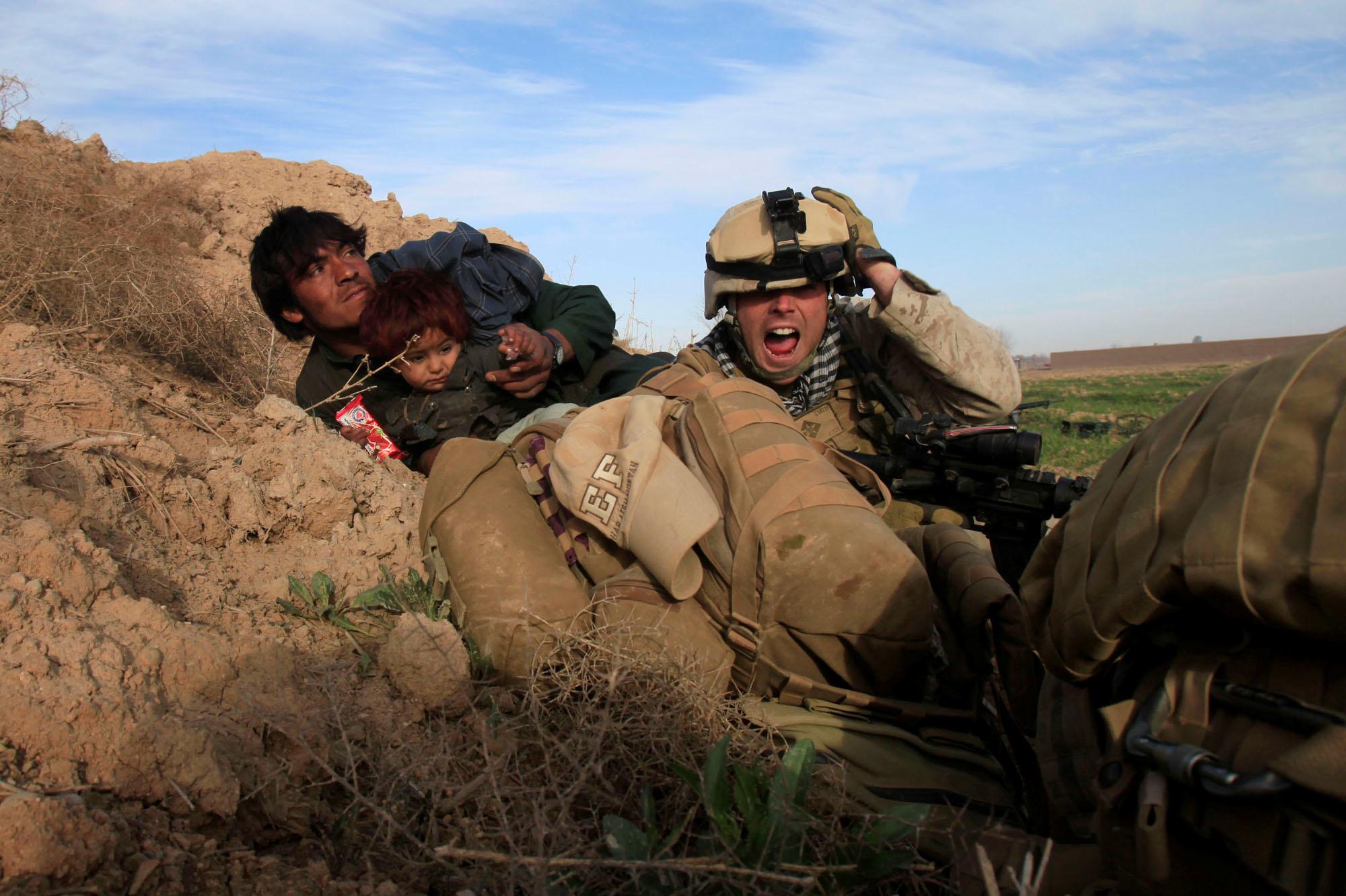 13 février 2010 : le caporal Chris Sanderson, 24 ans, originaire de Flemington, New Jersey, crie en essayant de protéger un Afghan et son enfant après que des combattants talibans aient ouvert le feu dans la ville de Marjah, dans le district de Nad Ali, province de Helmand.