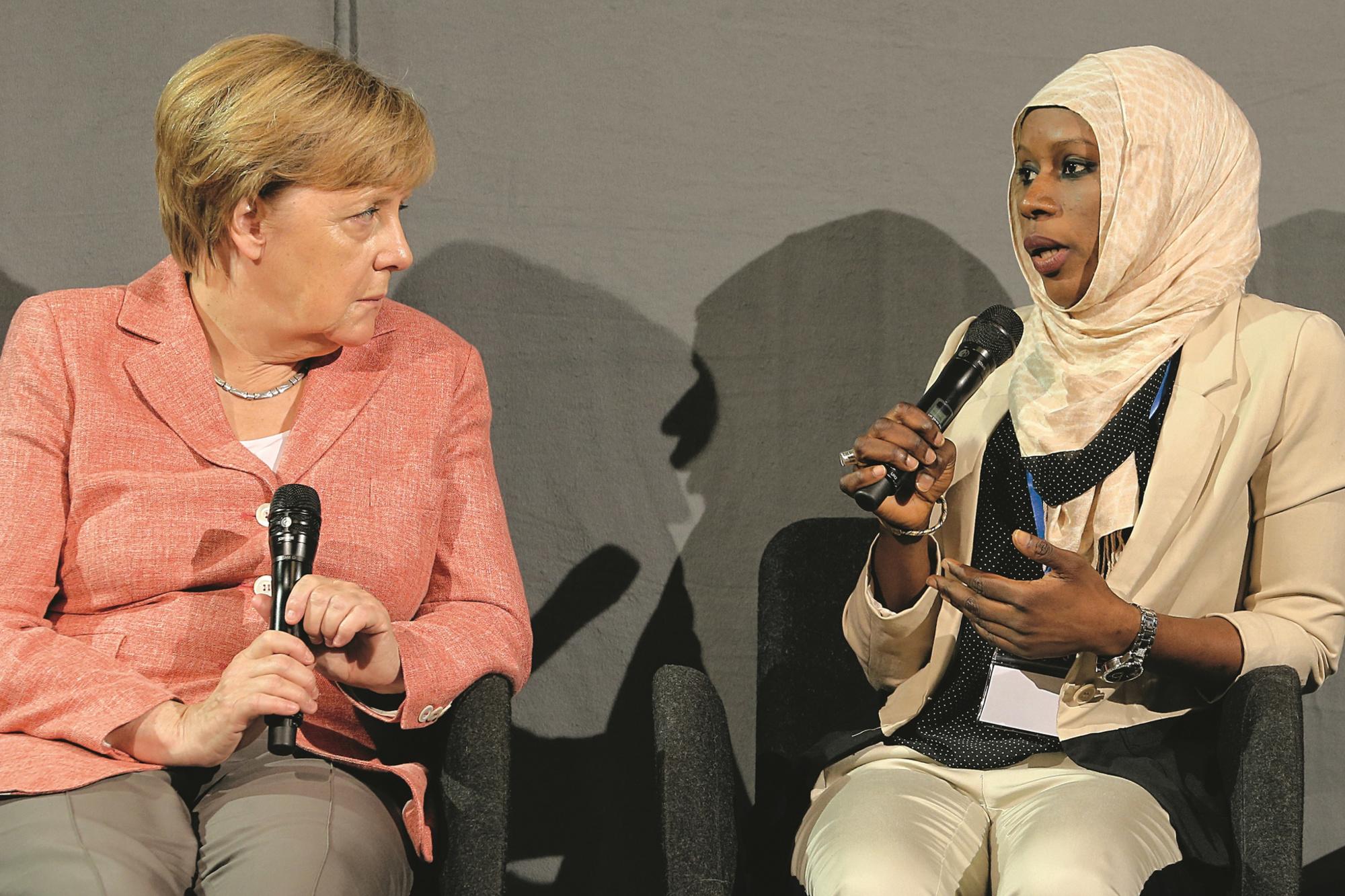 Angela Merkel en compagnie d'une jeune réfugiée de Gambie: entre ouverture et fermeté.