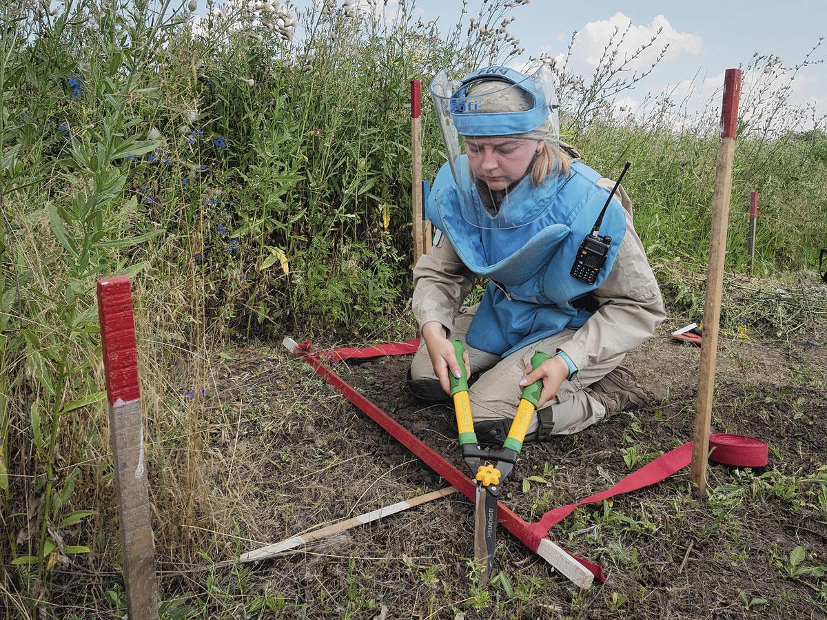 Entourée de piquets délimitant la zone à risque, Lioubov inspecte chaque centimètre carré du sol, progressant lentement par bande de dix centimètres. On estime qu'il faudra entre vingt et trente ans pour 