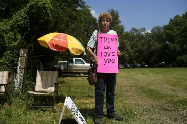 Een vrouw wacht op de plek waar Trumps helikopter zal landen