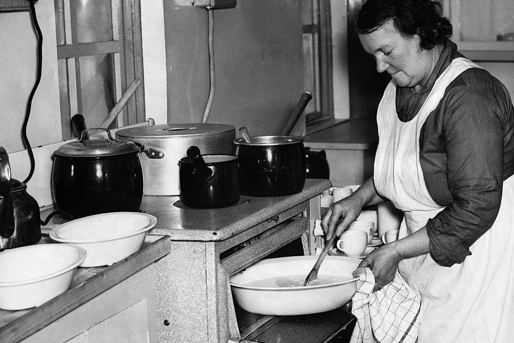 Een vrouw bereidt maaltijden voor kinderen in 1942