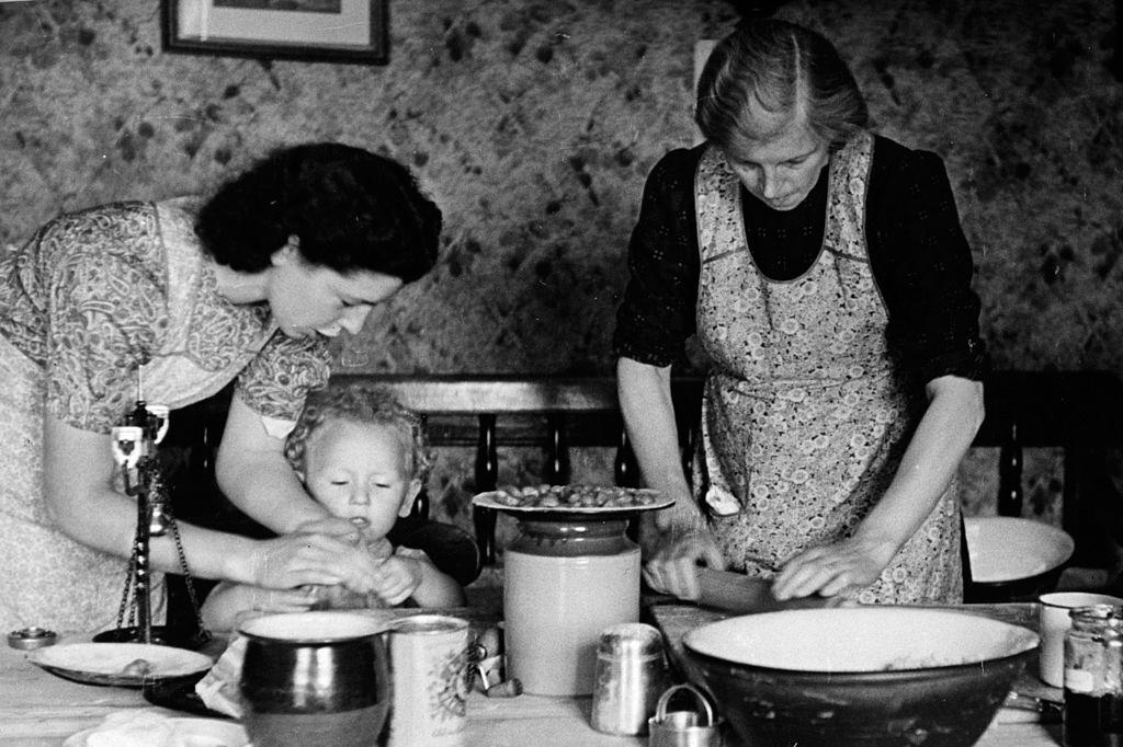 Een klein meisje helpt mee in de keuken, 1943.