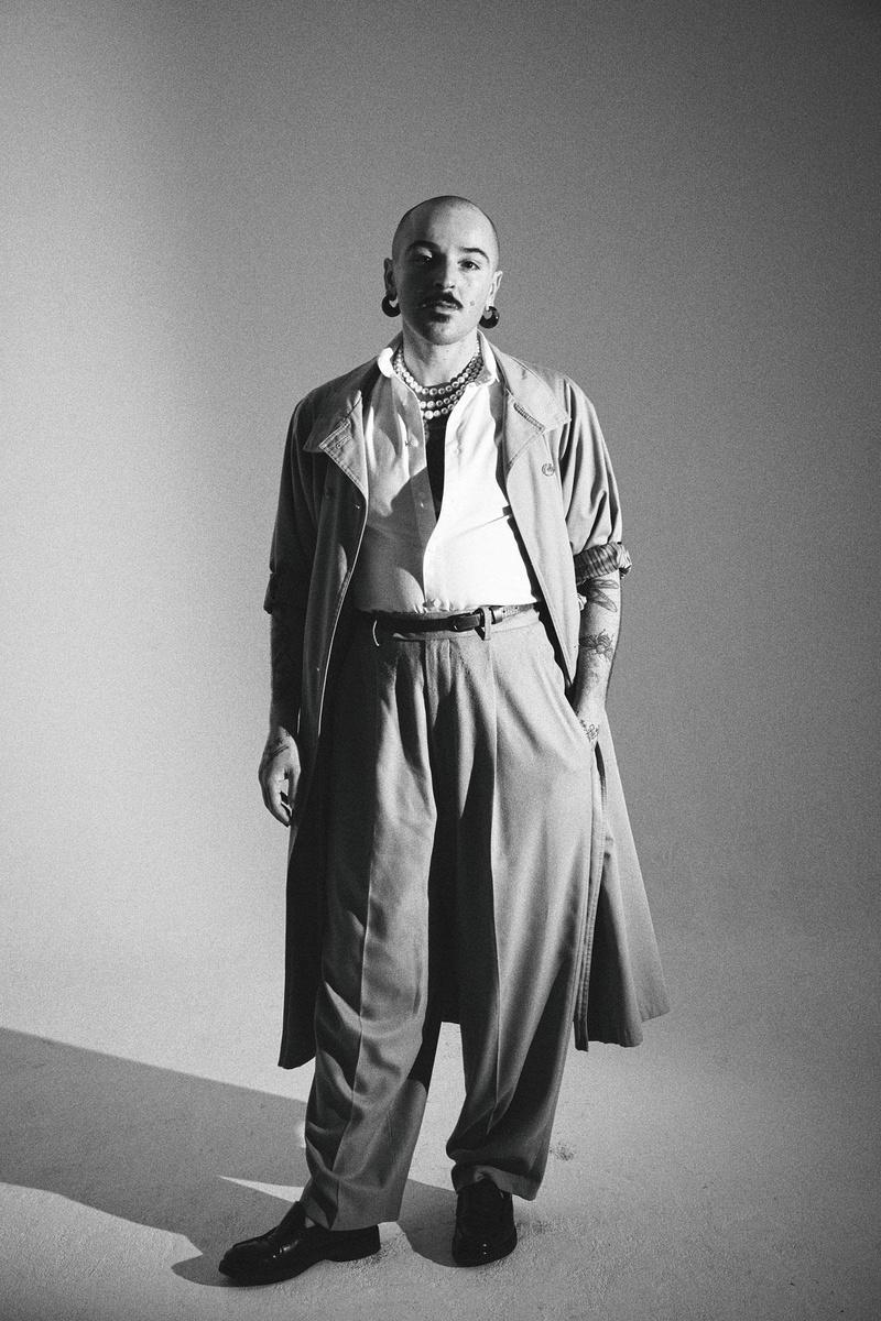 Jaouad Alloul in een look waar hij zich goed in voelt: openstaand hemd, hogetaillebroek en parels.