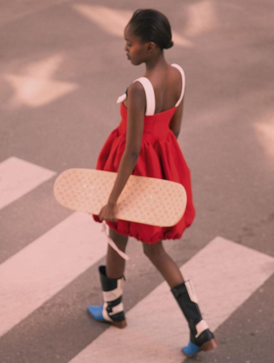Robe rouge, bottes et skateboard, Louis Vuitton.