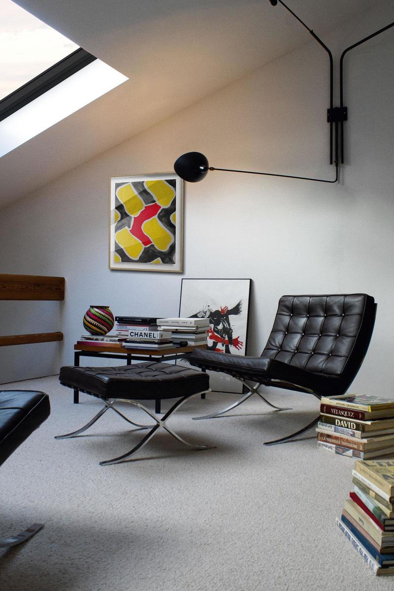 La mezzanine fait office de bureau. Posés sur le sol, une lithographie de Paul Rebeyrolle, des livres d'art et les monographies signées Julien Claessens. Le fauteuil Barcelona de Mies Van der Rohe et une table dénichée dans une brocante ont trouvé place sous la lampe de Serge Mouille qui met en lumière une lithographie de Claude Viallat.