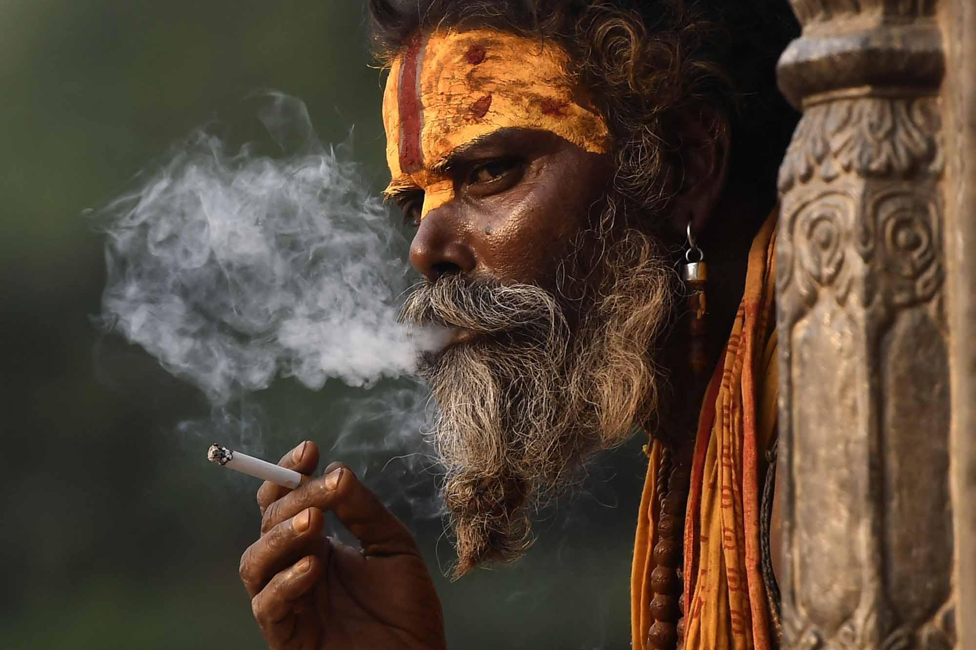 Un Sadhu fume une cigarette 