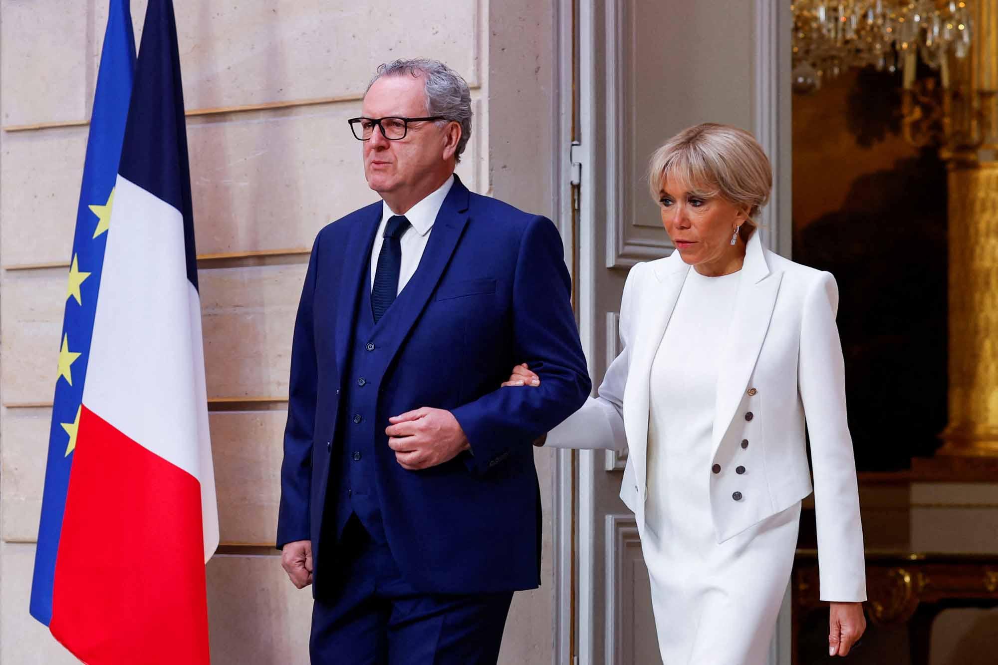 President of the French national assembly Richard Ferrand (L) and French President's wife Brigitte Macron (R) arrive at the Elysee presidential palace in Paris on May 7, 2022, to attend the investiture ceremony of Emmanuel Macron as French President, following his re-election last April 24. (Photo by GONZALO FUENTES / POOL / AFP) 