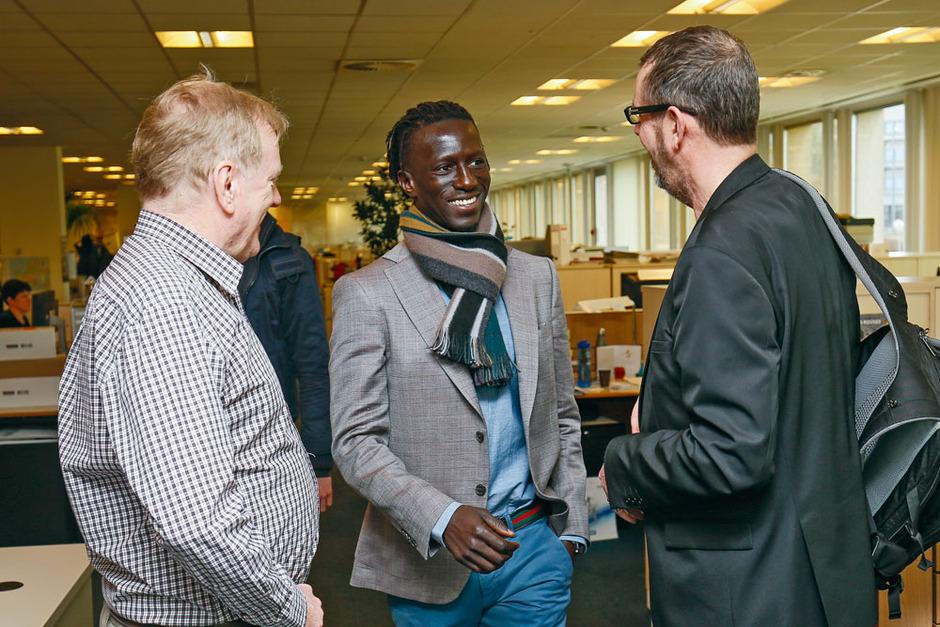 Mbaye Leye tussen hoofdredacteur Jacques Sys en journalist Christian Vandenabeele. 