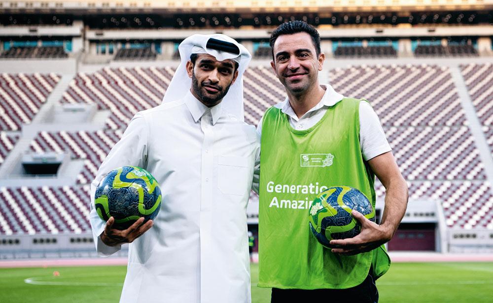 Als ambassadeur van het WK 2022 poseert Xavi hier samen met Hassan Al-Thawadi, de algemeen secretaris van het organisatiecomité van het WK.