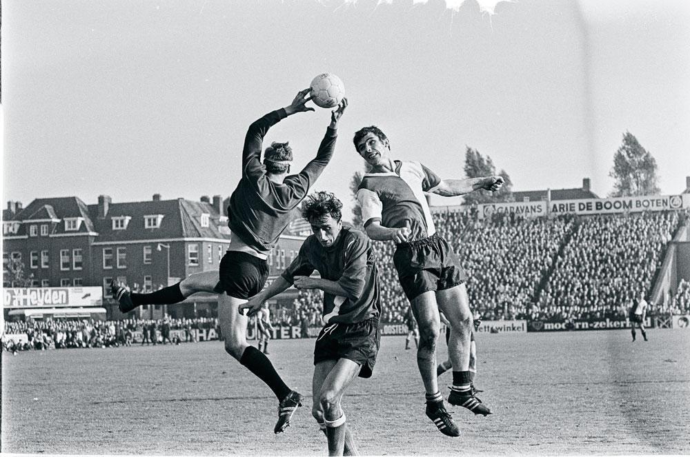Een beeld uit 1968. Doelman Jan van Beveren (Sparta) plukt de bal weg voor de neus van een opspringende Willem van Hanegem (Feyenoord).