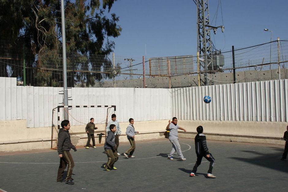 Schoolvoetbal in Oost-Jeruzalem. Op de achtergrond de Muur