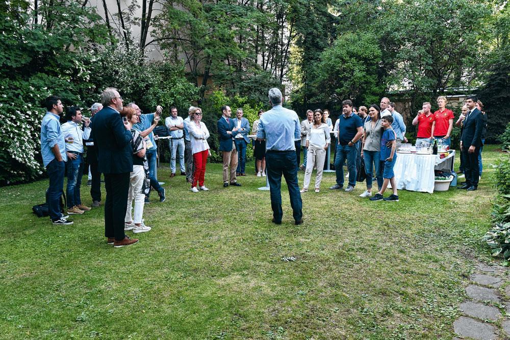 Vips en sponsors op een feestje in de tuin van de ambassade.