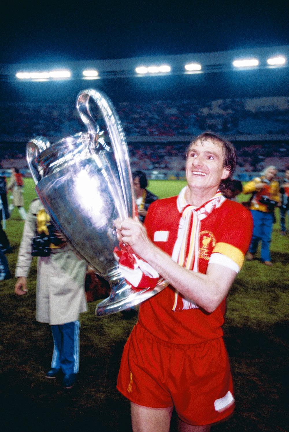 6 - Liverpool FC Kapitein Phil Thompson met zijn derde Europacup I (1981) in de lucht, in een shirt met plakband.