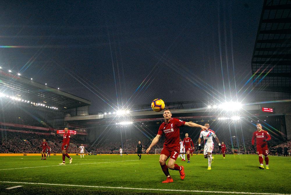 De stadiumcapaciteit van Anfield werd in 2016 opgetrokken tot 54.000 plaatsen. Hier ziet James Milner de bal buiten gaan.