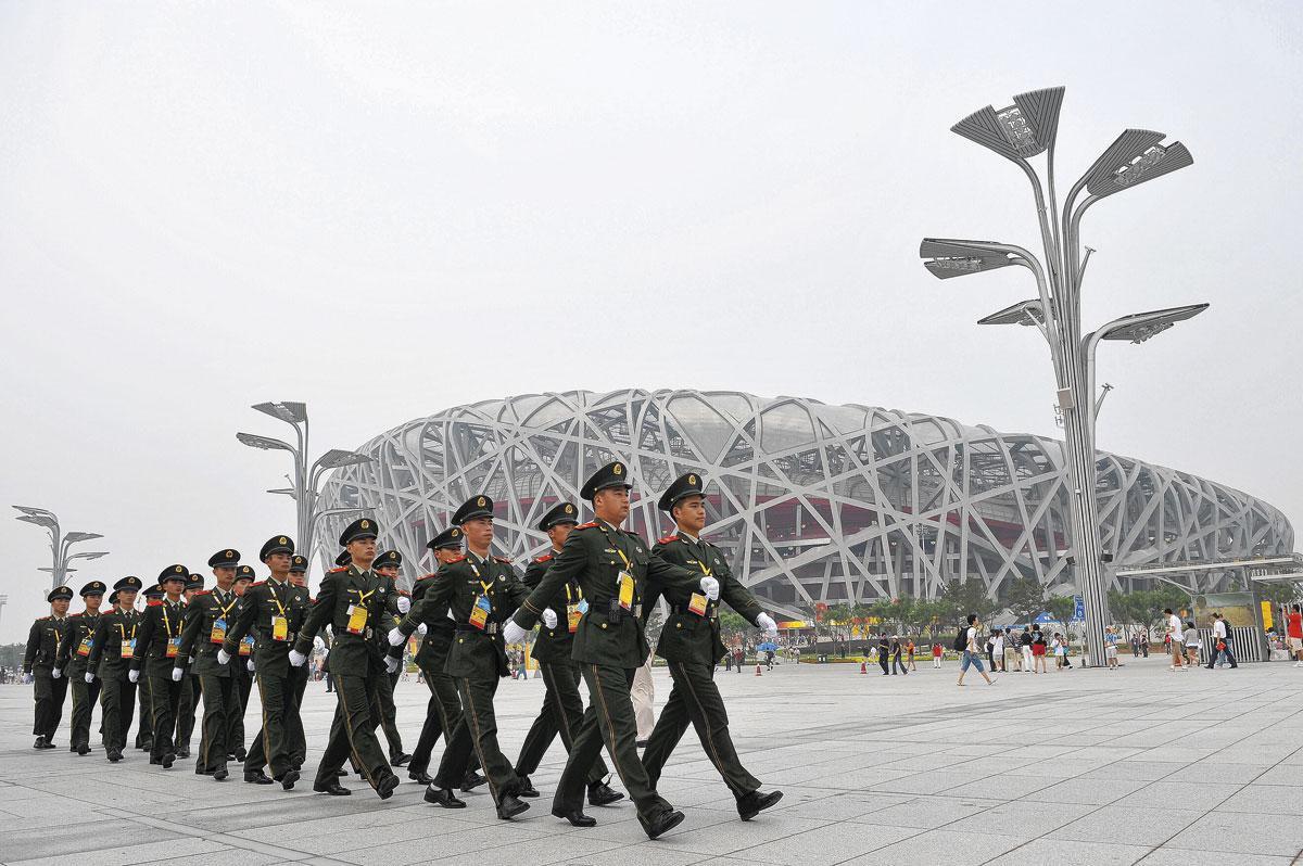 Chinese soldaten marcheren voor het Vogelnest-stadion. De veiligheid in en rond de olympische sites wordt zeer strikt.