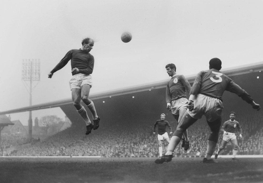 Een krachtige kopbal van Bobby Charlton, in en tegen Liverpool in oktober 1964.