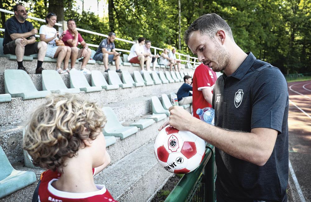 Antwerpspeler Geoffry Hairemans signeert een bal voor een jonge fan.