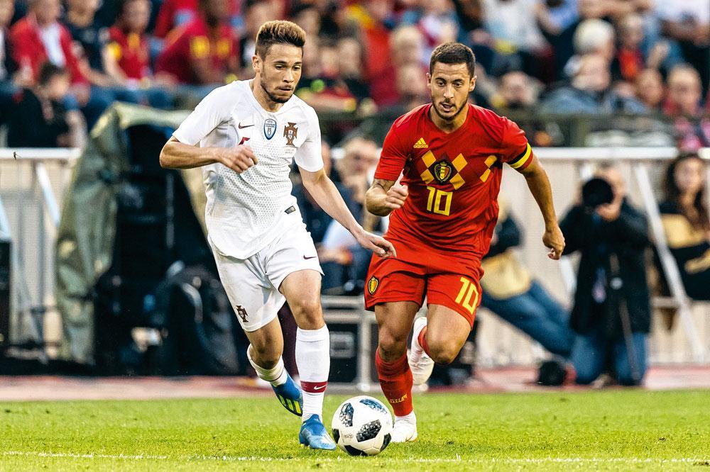 Raphaël Guerreiro en Eden Hazard spurten naar de bal. Hazards maatje Christian Benteke haalde de definitieve selectie niet.