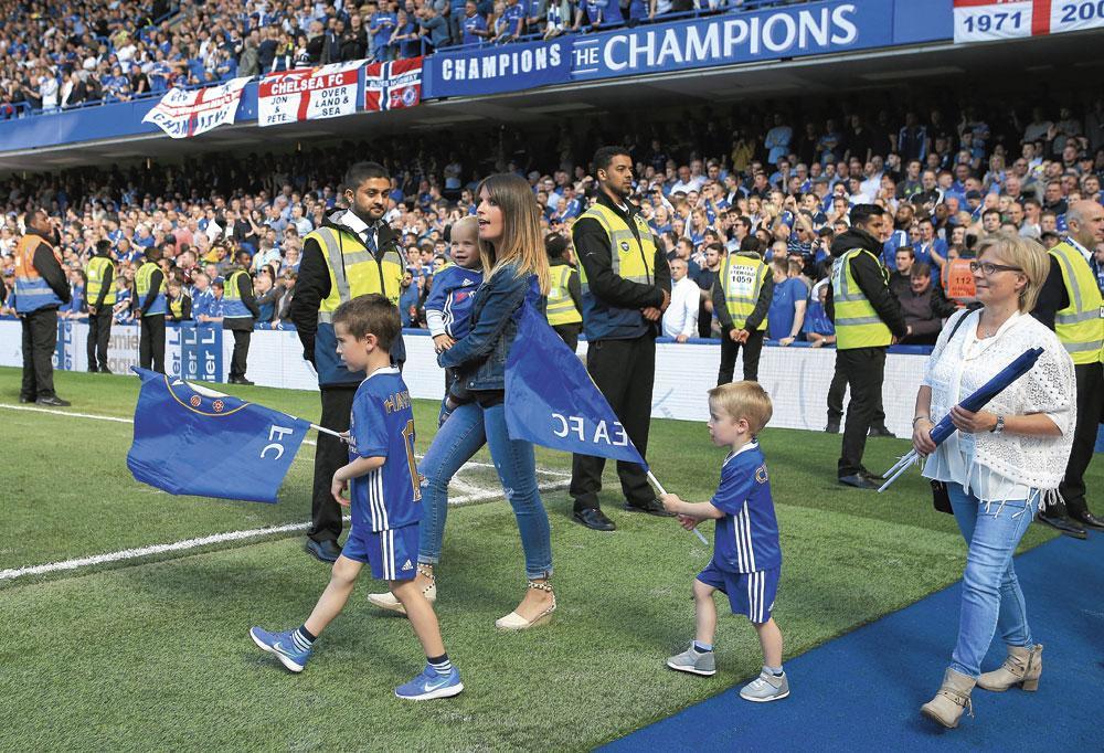 Het gezin van Eden Hazard komt zelden in het openbaar. Hier wandelt zijn vrouw Natacha met Yanis, Léo en Samy het veld van Chelsea op.