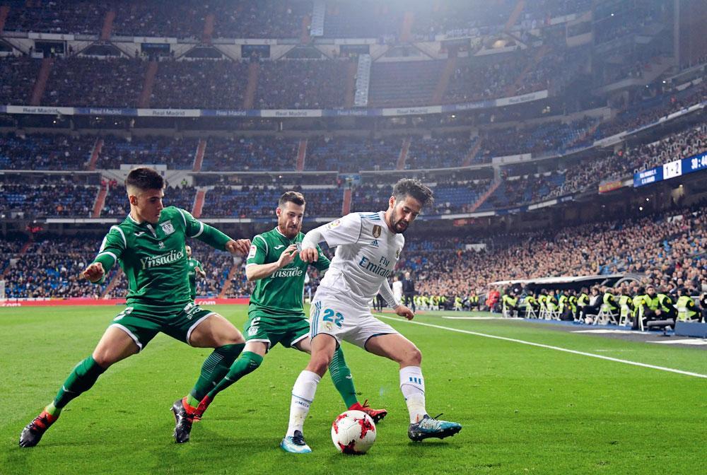 Isco, een van de vedetten van Real Madrid, in duel met Leganés-verdedigers Tito en Unai Bustinza. De club uit een buitenwijk van Madrid stuntte door De Koninklijke uit de Copa del Rey te stoten.