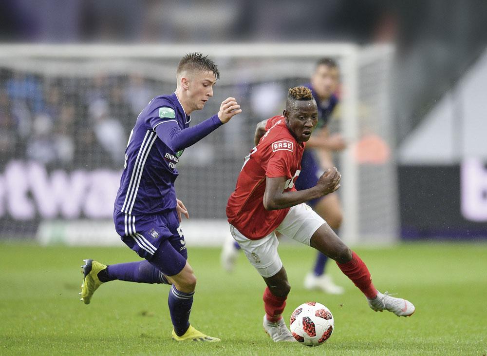 Moussa Djenepo probeert Alexis Saelemaekers in de luren te leggen.