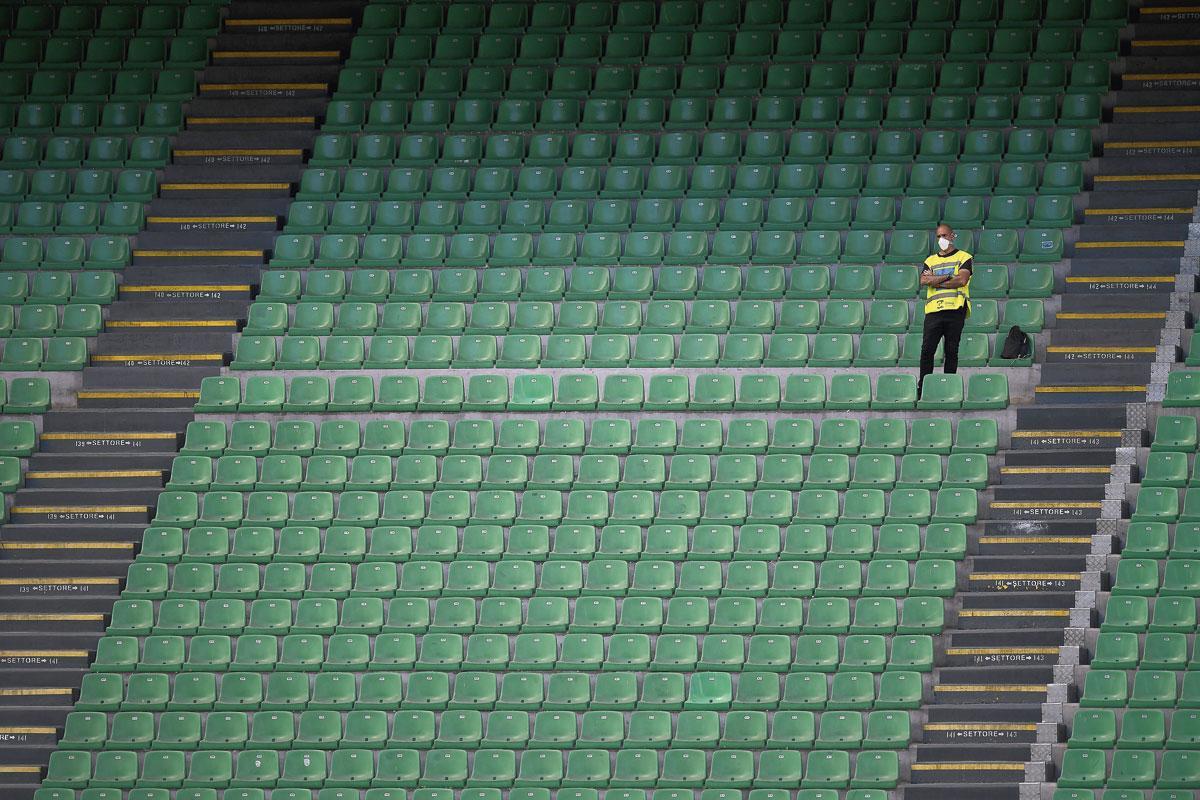 Een steward, eenzaam en verlaten in een voetbalstadion.