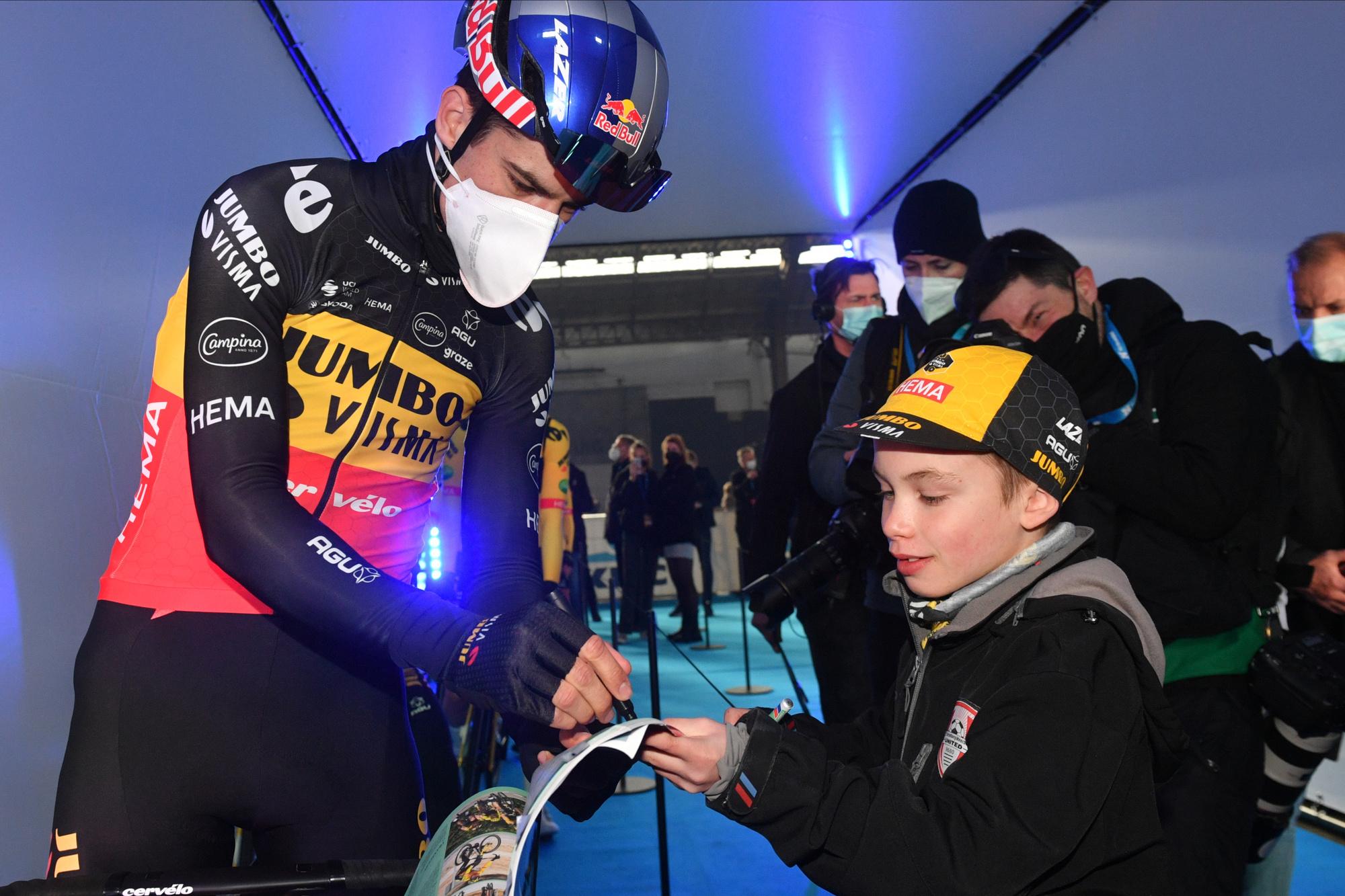 Van Aert signant un autographe à un jeune fan avant le départ du circuit Het Nieuwsblad.