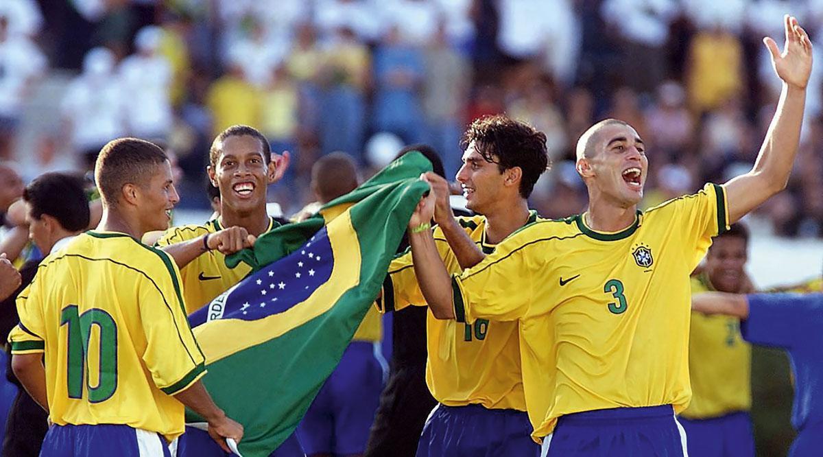 À la fin du dernier millénaire, le Brésil se présente aux Jeux Olympiques de Sydney avec un tout jeune Ronaldinho (deuxième en partant de la gauche). Éliminé en quart de finale par le Cameroun, Ronnie fait ses débuts sur le Vieux Continent un an plus tard sous le maillot du PSG, avant de grimper sur le toit du monde suite à son passage au Barça. Ballon d'Or en 2005, il fera une quinzaine d'années plus tard un séjour derrière les barreaux à cause de graves problèmes financiers.