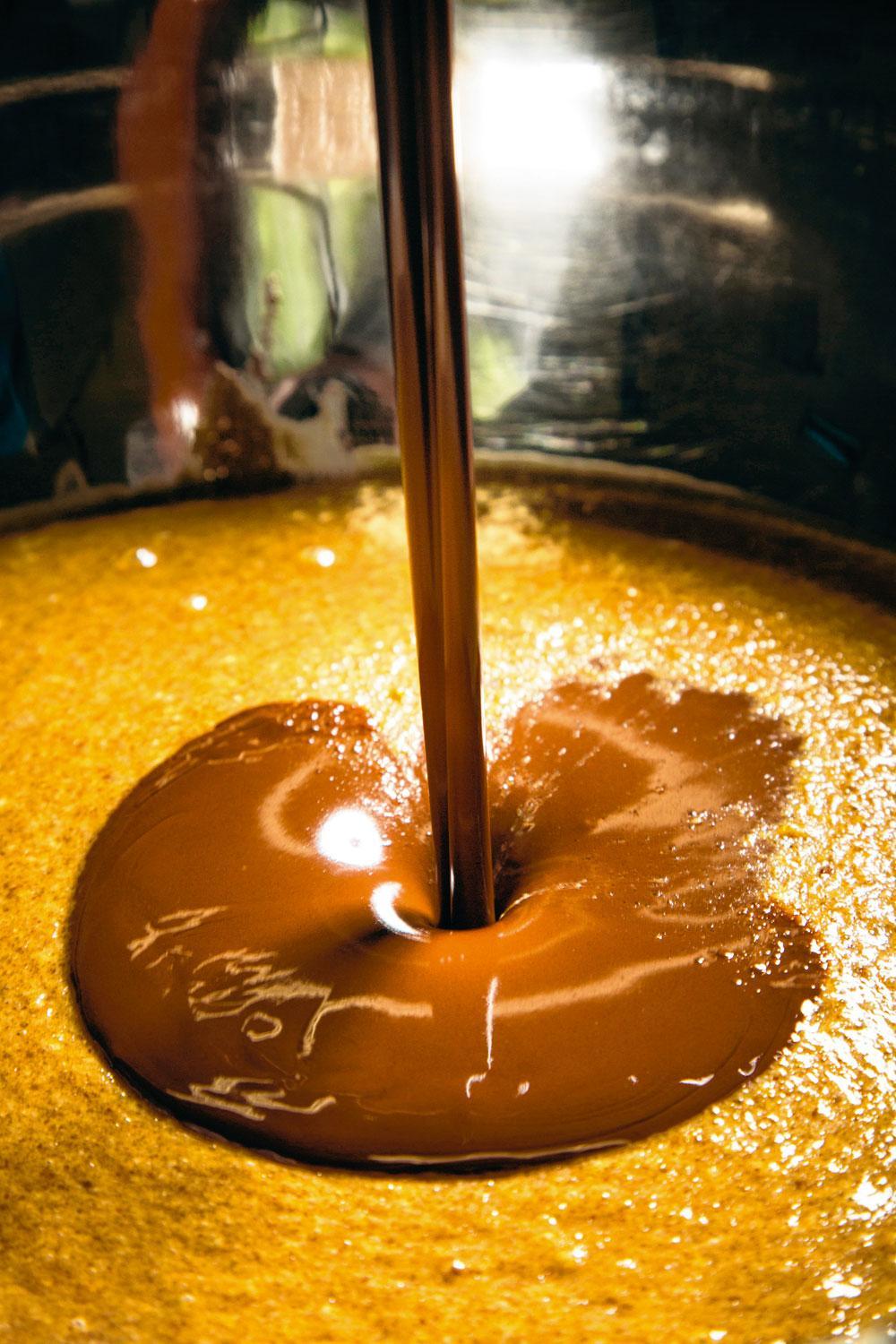 Mengen - Vervolgens wordt de vulling gemengd met de chocolade en tot 22 graden Celsius opgewarmd. Die temperatuur is ideaal om de beide ingrediënten grondig met elkaar te vermengen. De chocolade die in dit recept wordt gebruikt, wordt elders geproduceerd. 