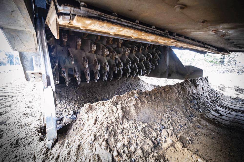 3 Stevige bedding De vroegere onderlaag van zand van de grote waterputten naast de autosnelweg, wordt verstevigd met magere betonkiezels en cement. De freesmachine graaft en mengt de stenen samen met de uitgestrooide cement tot een stevige bedding. Het geheel wordt besproeid met water en aangestampt door plet- en bandenwalsen.