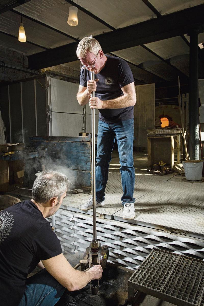 IN DE MAL Zodra de bol mooi homogeen en gekalibreerd is, wordt er een laatste keer in geblazen. Ditmaal blaast de glasmaker in een mal die de bol zijn uiteindelijke vorm geeft. Nadat het voorwerp uit de mal is gehaald, moet het nog worden losgemaakt van de blaaspijp. Dat doet de meester-glasmaker door er een kerf in te trekken die hij kortstondig koelt. Tijdens het afkoelen krijgt het voorwerp geleidelijk zijn definitieve kleur. Het afgewerkte voorwerp heeft nog  altijd een temperatuur van 200 tot 300 graden. Het is tijd om het 24 uur in de koeloven te zetten.