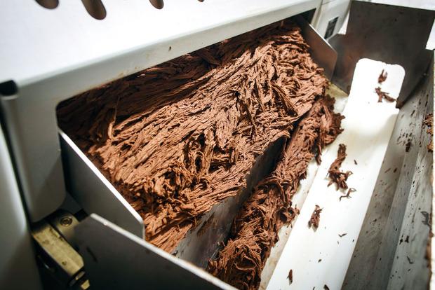 De plus en plus fin et lisse - L'affinage comporte deux étapes. D'abord, le cacao liquide sortant de la mélangeuse traverse des cylindres de plus en plus serrés. Au bout de ce processus, les grains de cacao ne font plus que 80 microns de long. Le chocolat se présente sous forme de petits blocs. Dans une deuxième phase, ces morceaux sont transformés en copeaux dans une lamineuse et les grains ne mesurent plus que 20 microns. Enfin, le chocolat est refroidi par un circuit d'eau. C'est à l'affinage que le chocolat fini doit être parfaitement lisse.