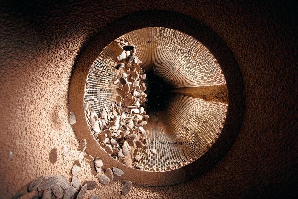 2. La rouleuse - Lorsqu'il est à bonne température, le chocolat est coulé dans les moules qui contiennent l'empreinte des futures dragées. On lui fait alors subir un choc thermique à -13 ° C afin qu'il durcisse et prenne forme. Les plaques de chocolat sont ensuite cassées en morceaux, à l'aide d'un tamis cylindrique rotatif.