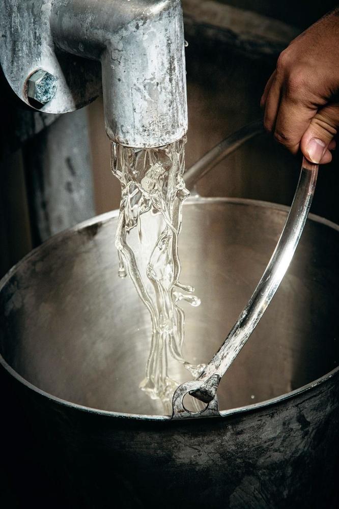 3. La cuisine - Le chocolat est au coeur de la dragée. Mais dans la cuisine, un ouvrier prépare les autres ingrédients qui seront progressivement ajoutés à la recette, comme la gomme arabique ou le sirop de glucose (un mélange de sucre et d'eau chaude).