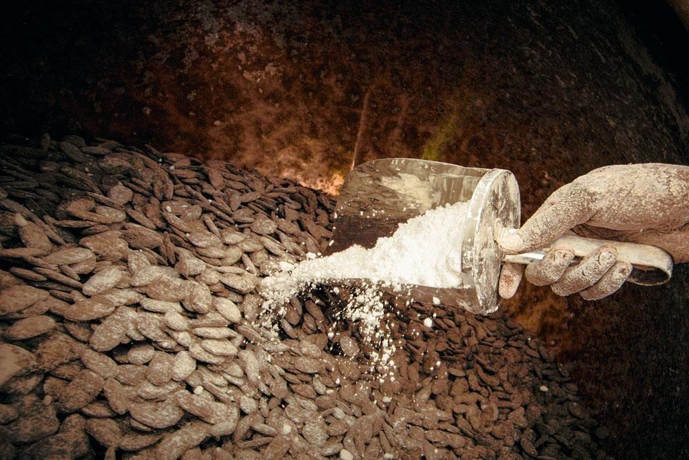 4. Le gommage Les morceaux de chocolat sont ensuite disposés dans les turbines, sortes de bétonneuses en cuivre qui mélangent les ingrédients et homogénéisent les dragées. La gomme arabique est ajoutée en premier. Celle-ci fera office de colle. Une première couche de sucre impalpable est ensuite insérée.