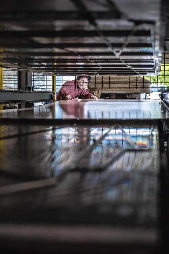 Presse à découper - La machine la plus imposante du hall de production d'Onak est la presse à découper. Au coeur de ce mastodonte de 6 m sur 30 m, on trouve une matrice en aluminium qui façonne les lignes de pliage dans les plaques de plastique. A la sortie de la presse, les bords superflus sont automatiquement découpés.