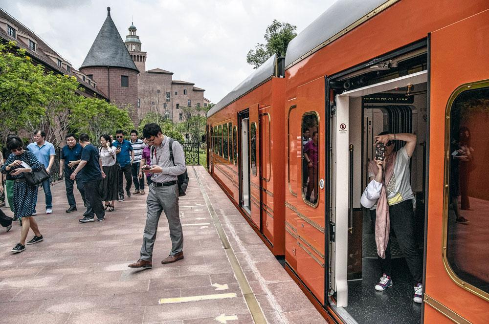 Le nouveau campus de Dongguan, près de Shenzen - A bord d'un petit train rouge semblant descendre des montagnes suisses, visiteurs et employés de Huawei voient défiler en neuf minutes douze fausses villes d'inspiration européenne.