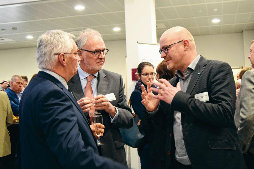 Jean-Jacques Nonet et Jef Lembrechts, président de la Vlaamse Confederatie Bouw, écoutent avec attention Arnaud Deplae, secrétaire général de l'UCM.
