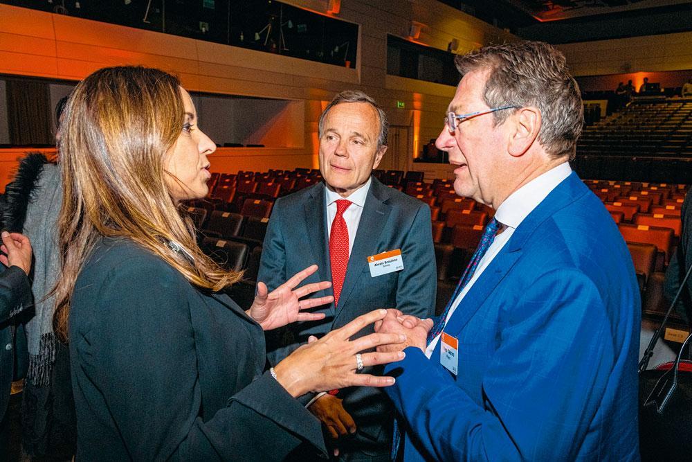 La nouvelle CEO de Solvay, Ilham Kadri, captive l'attention d'Alexis Brouhns, senior executive president pour la région Europe chez Solvay, et Yves Caprara.