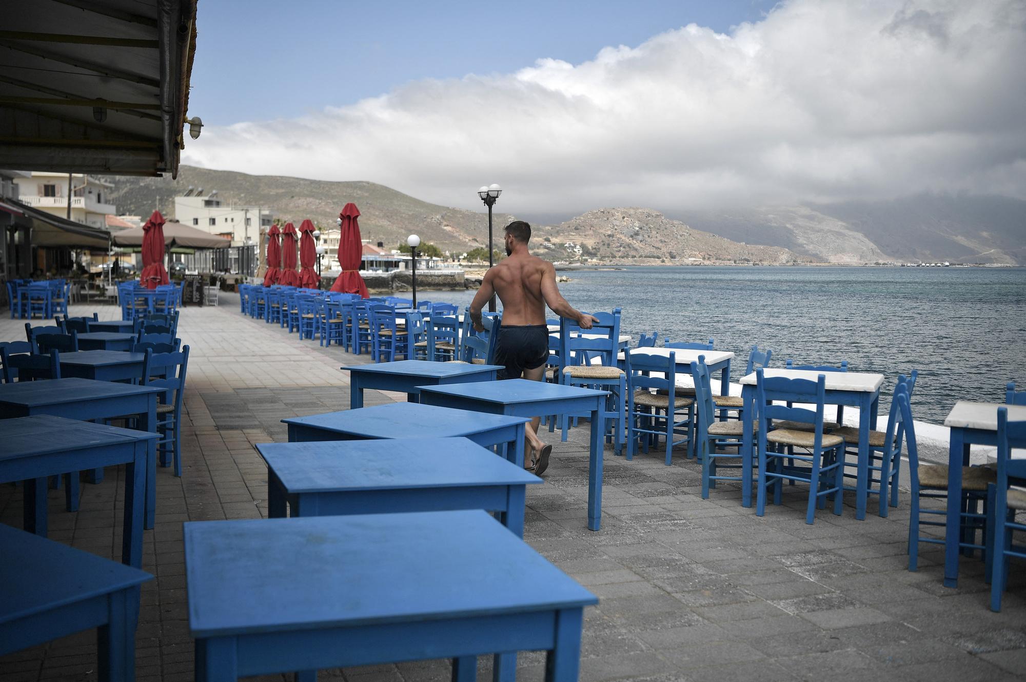 Alexandros Koukourakis, prépare la terrasse de sa taverne, à Kissamos