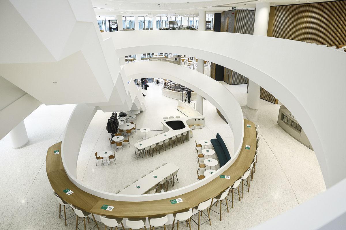 A l'image du vaste atrium et de son grand escalier, qui surplombe différentes zones d'activité informelles, le design intérieur met l'accent sur les notions de 