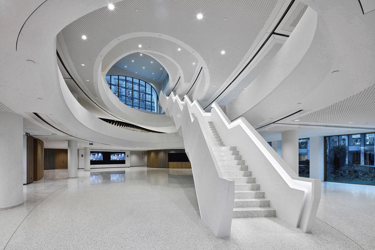 A l'image du vaste atrium et de son grand escalier, qui surplombe différentes zones d'activité informelles, le design intérieur met l'accent sur les notions de 