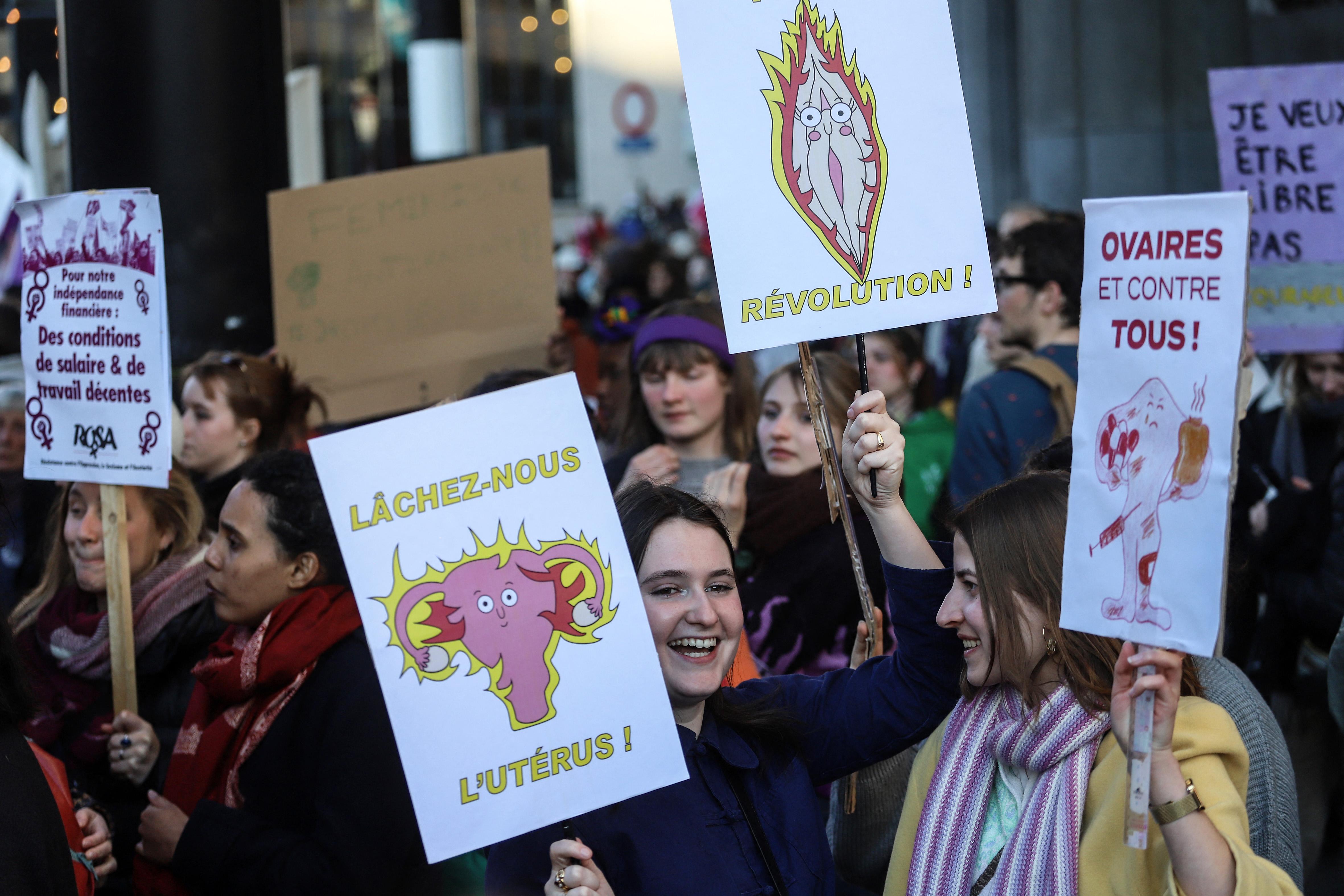 Slogans féministes humorisqtiques sur des pancartes lors de la manifestation du 8 mars 2022 à Bruxelles : "lachez-nous l'utérus" et ovaires et contre tous"