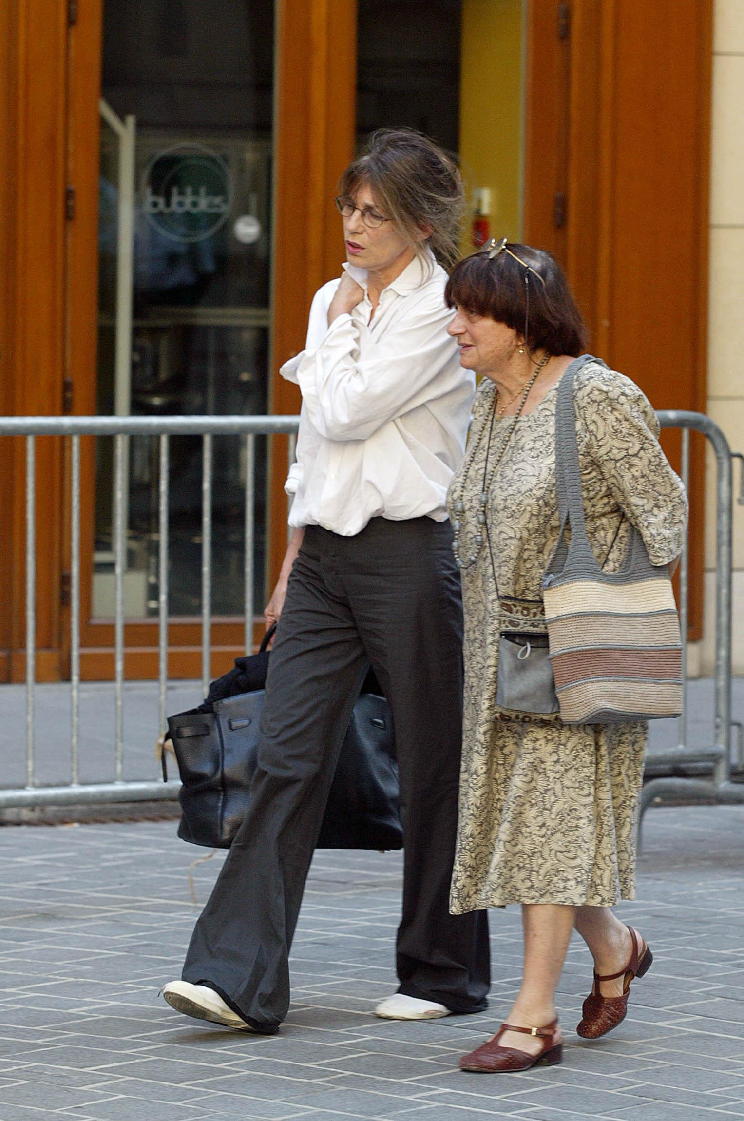 l'actrice et chanteuse Jane Birkin (G) et la réalisatrice Agnès Varda quittent le théâtre Edouard VII, le 06 août 2003 à Paris, où a été rendu un hommage à l'actrice française Marie Trintignant, décédée le 01 août dernier.   AFP PHOTO MARTIN BUREAU (Photo by Martin BUREAU / AFP)