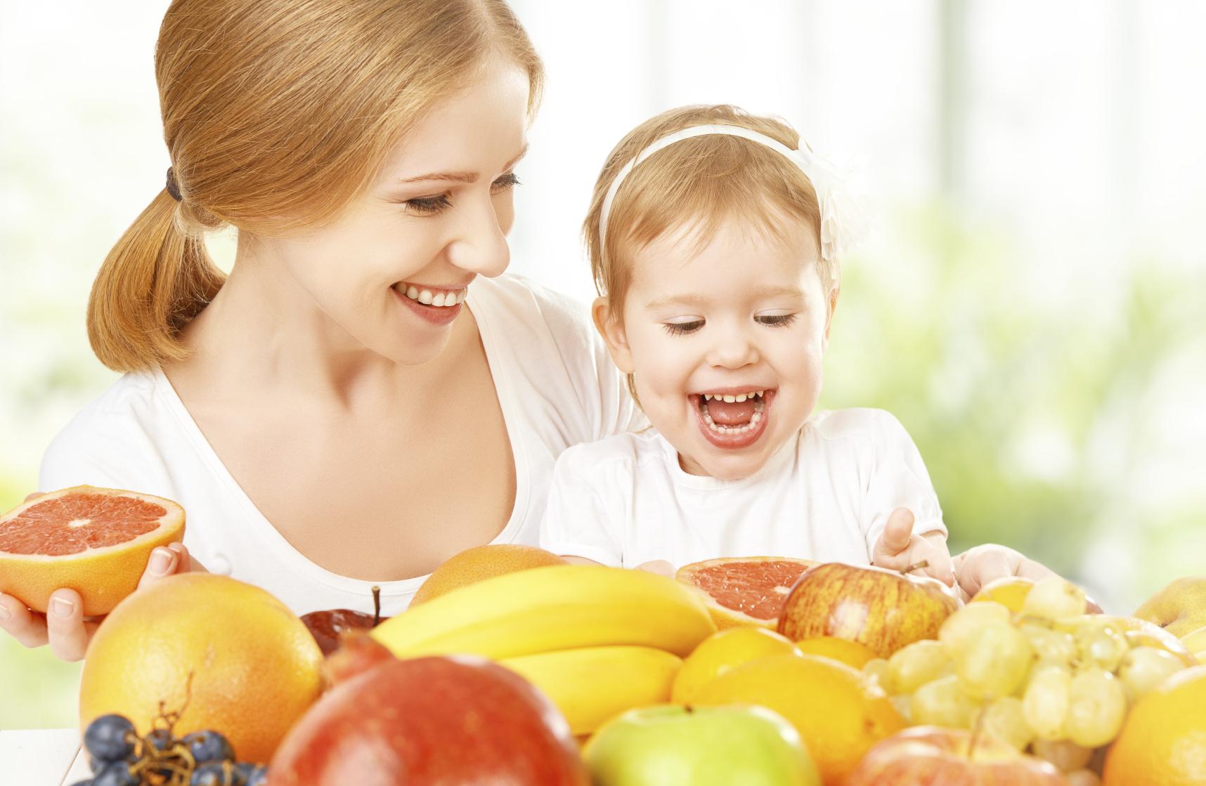 happy family mother and daughter little girl, eat healthy vegetarian food, fruit