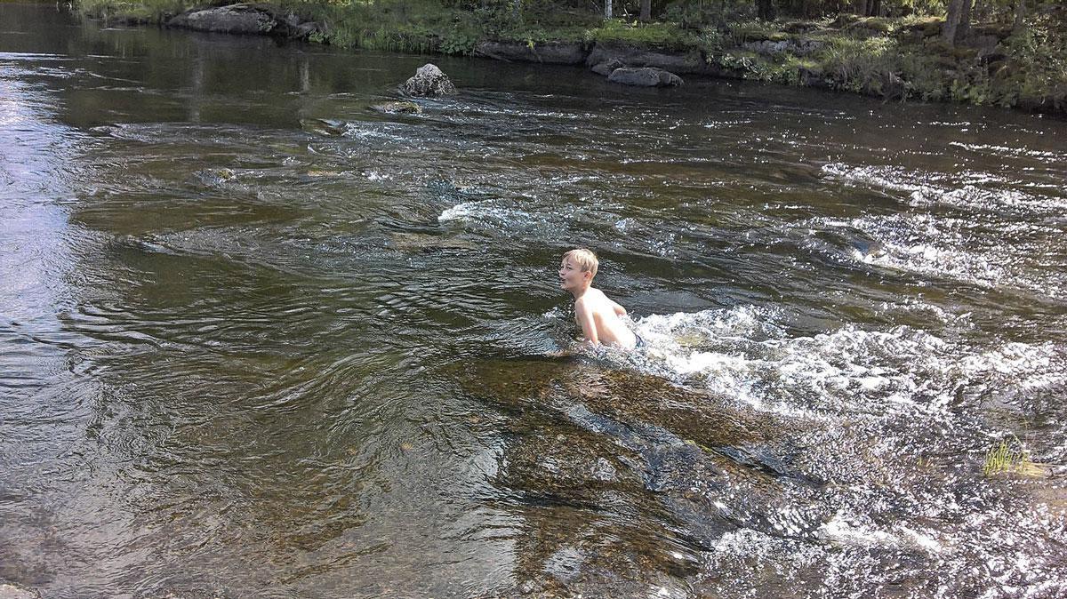 De kleinzoon duikt na een saunabeurt in de rivier.