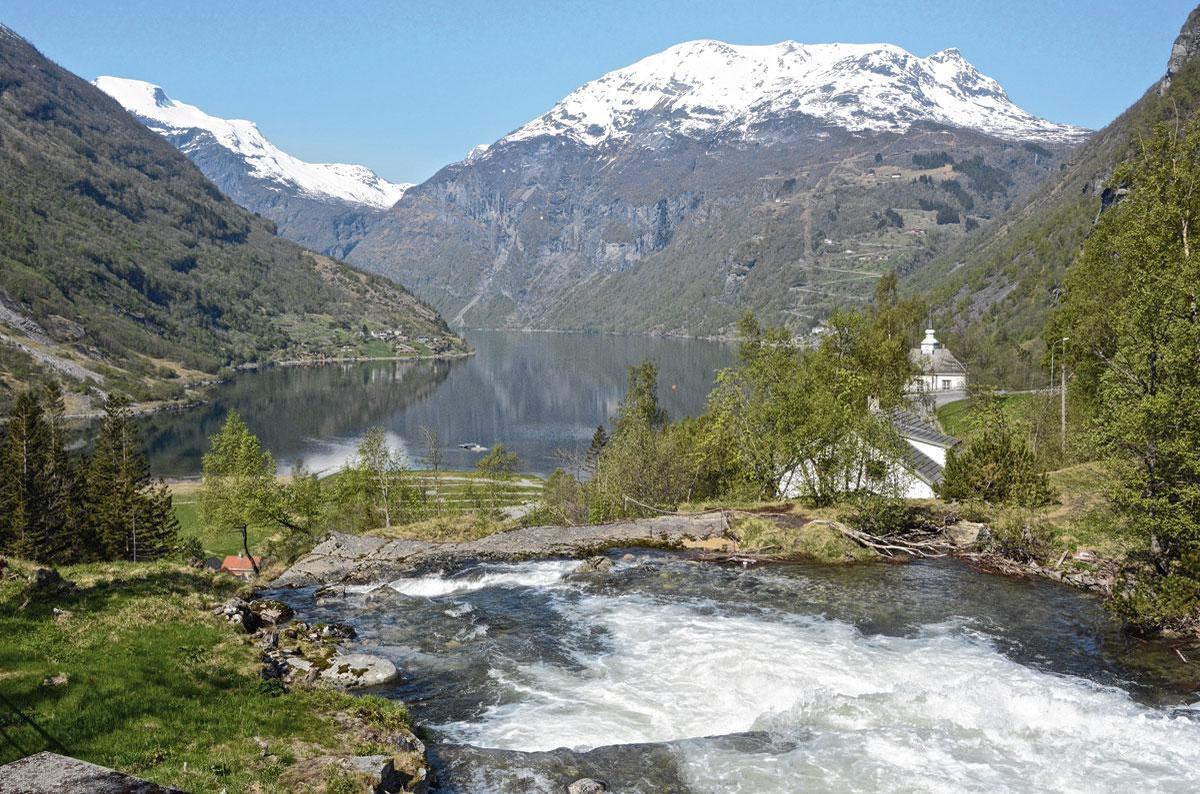 De Storfossen waterval loopt over in de Geiranger fjord .