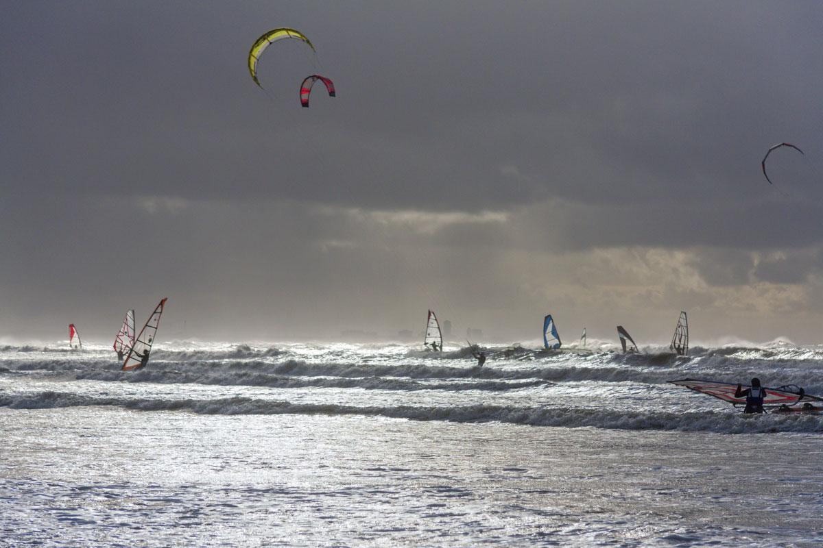 Wanneer de lucht diepgrijs kleurt en de zilveren golven woelig tekeergaan,  kleuren plank- en kitesurfers de horizon, op zoek naar de ultieme kick.